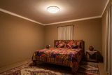 Solar ceiling light glowing in a bedroom with African-style bedding